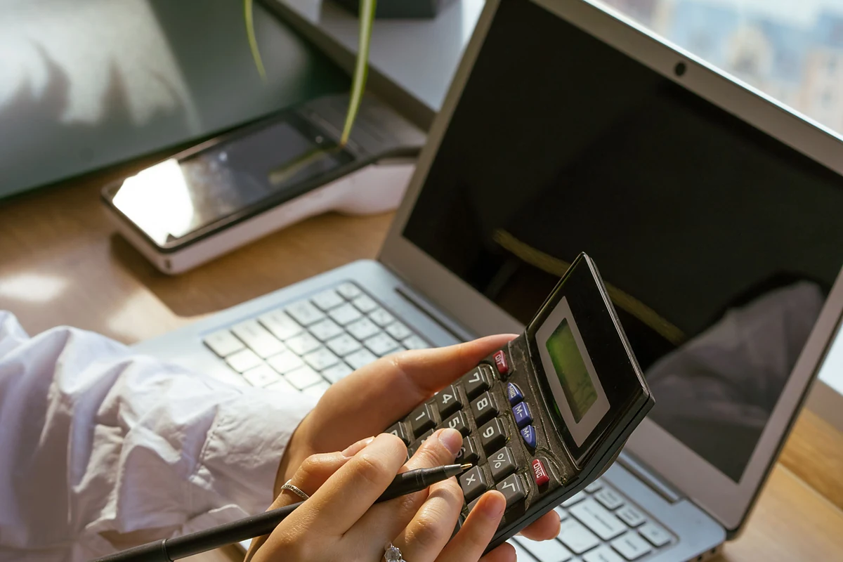 A self-employed professional reviewing financial records on a laptop